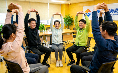 企业组织员工在会议室进行团体健身活动，提升团队活力
